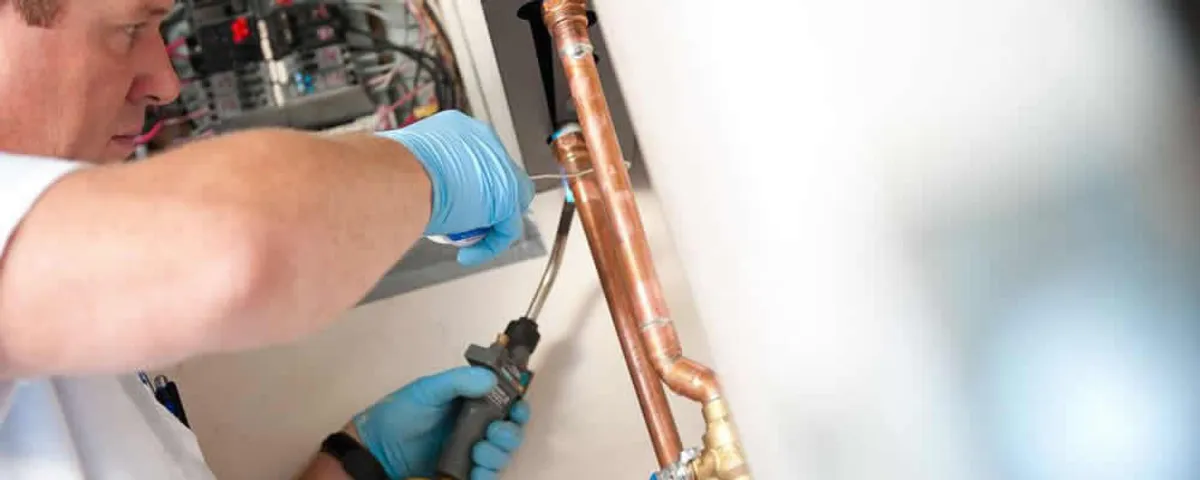 Water heater repair technician testing copper pipe connections and controls in Saint Petersburg, FL